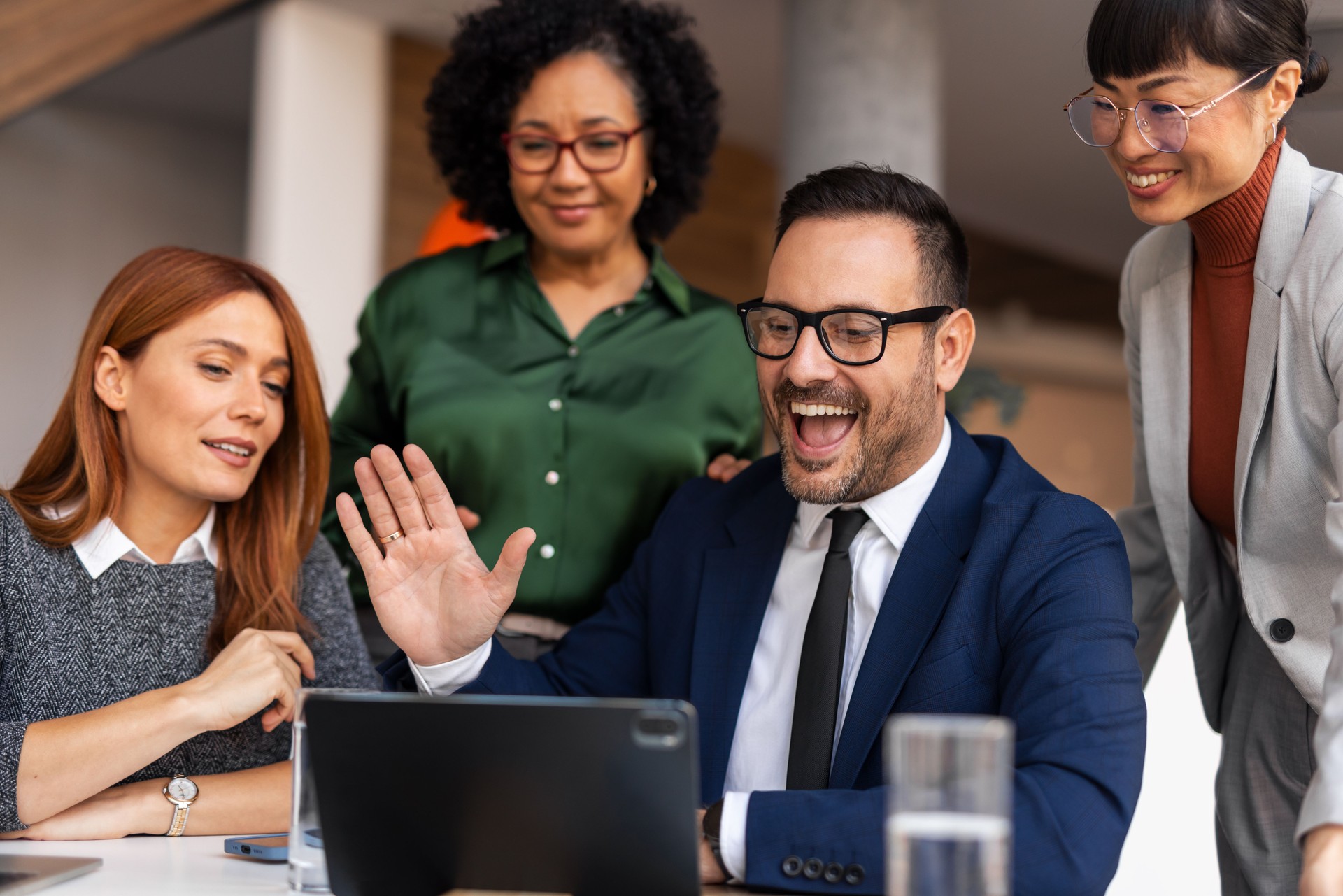 Équipe d’affaires souriante collaborant dans un bureau moderne par vidéoconférence